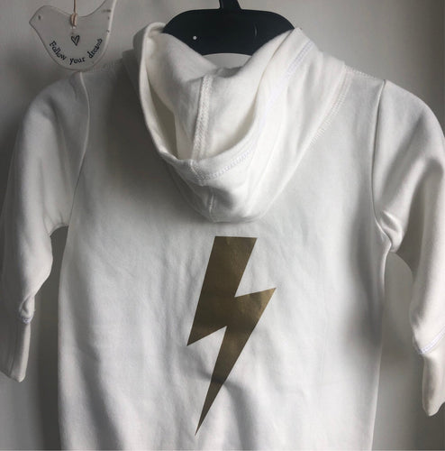 this is a cream organic babygro with a gold printed lightening bolt on it on it